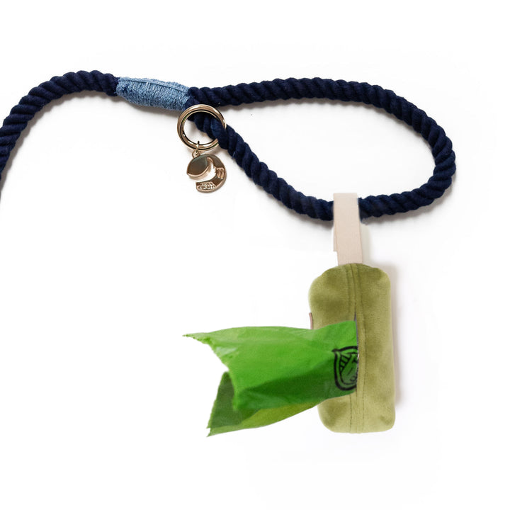 Avocado green velvet poop bag holder shown from bottom and attached to leash handle