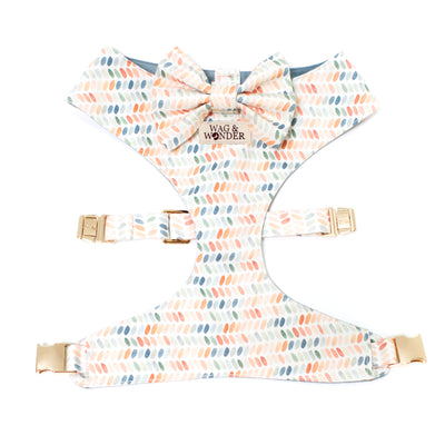 Reversible dog harness with bow tie in dusty blues, terra cotta, and sage greens in dot print.