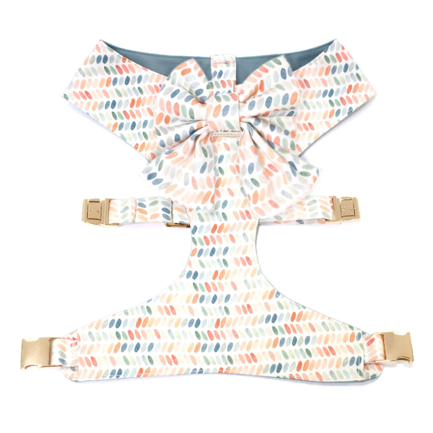 Reversible dog harness and bow tie in modern dot print with shades of blue, terra cotta, and green.