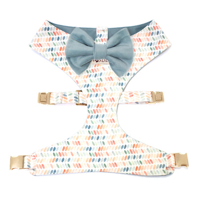 Reversible dog harness in multi-color polka dot print with blue velvet bow tie and gold hardware.