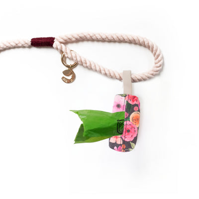 Floral waste bag holder shown from bottom attached with vegan leather loop to leash handle