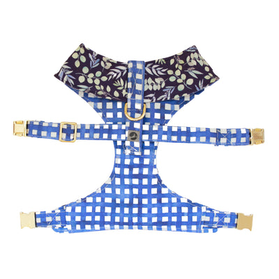 Top view of reversible dog harness with gold hardware in indigo background with mult-color foliage