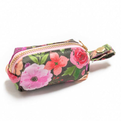 Side view of fabric rectangular pouch with zip closure and snap loop for poop bags in pink multi floral on gray
