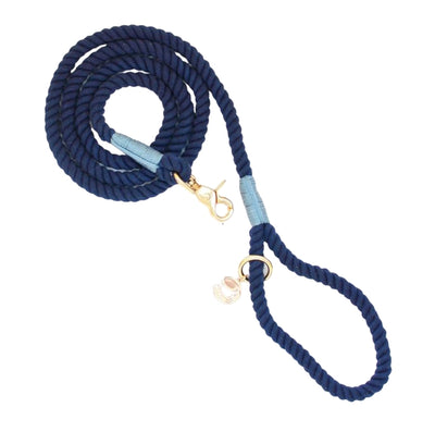 Rope dog leash arranged in coil with gold hardware in navy blue with  light blue thread