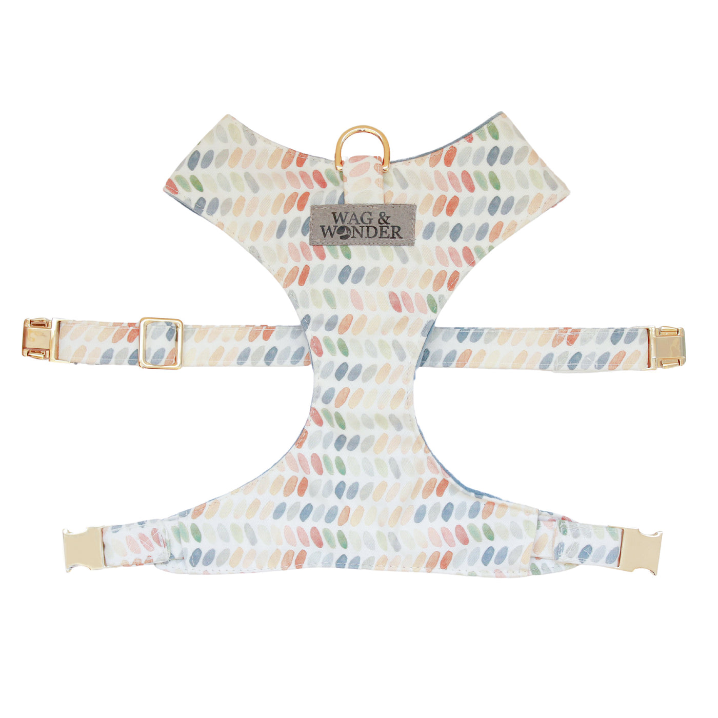 Front view of reversible dog harness with gold hardware in multi-color ovals