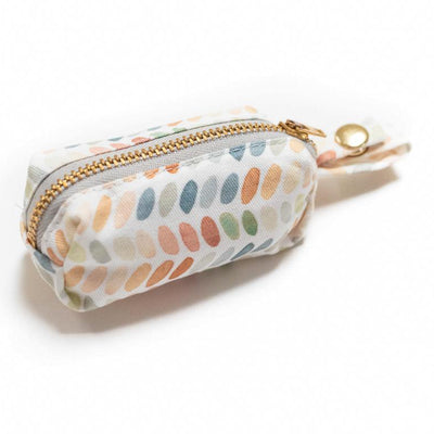 Side view of fabric rectangular pouch with zip closure and snap loop for poop bags in multi-color ovals